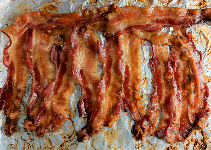 https://www.onthegobites.com/wp-content/uploads/2018/10/bacon-in-oven-on-tray.jpg
